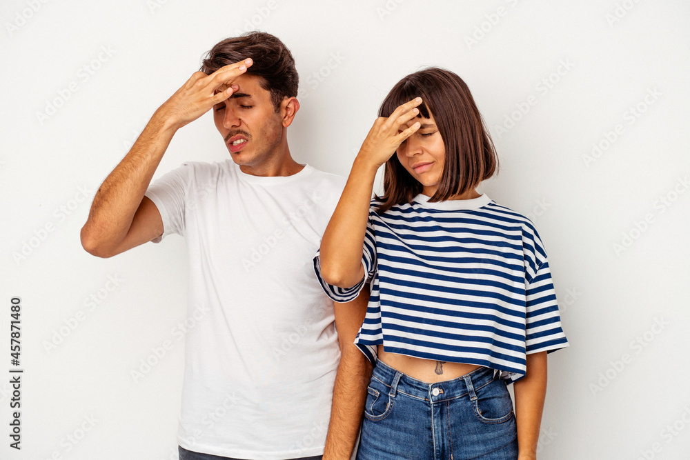 Young mixed race couple isolated on white background having a head ache, touching front of the face. Young mixed race couple isolated on white background having a head ache, touching front of the face.