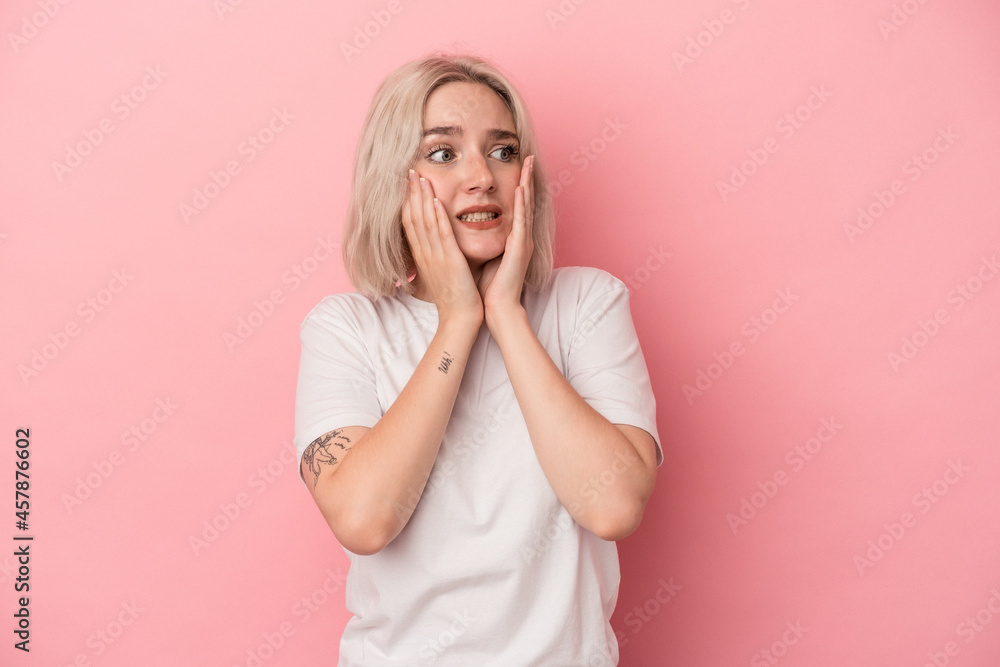 Young caucasian woman isolated on pink background scared and afraid. Young caucasian woman isolated on pink background scared and afraid.