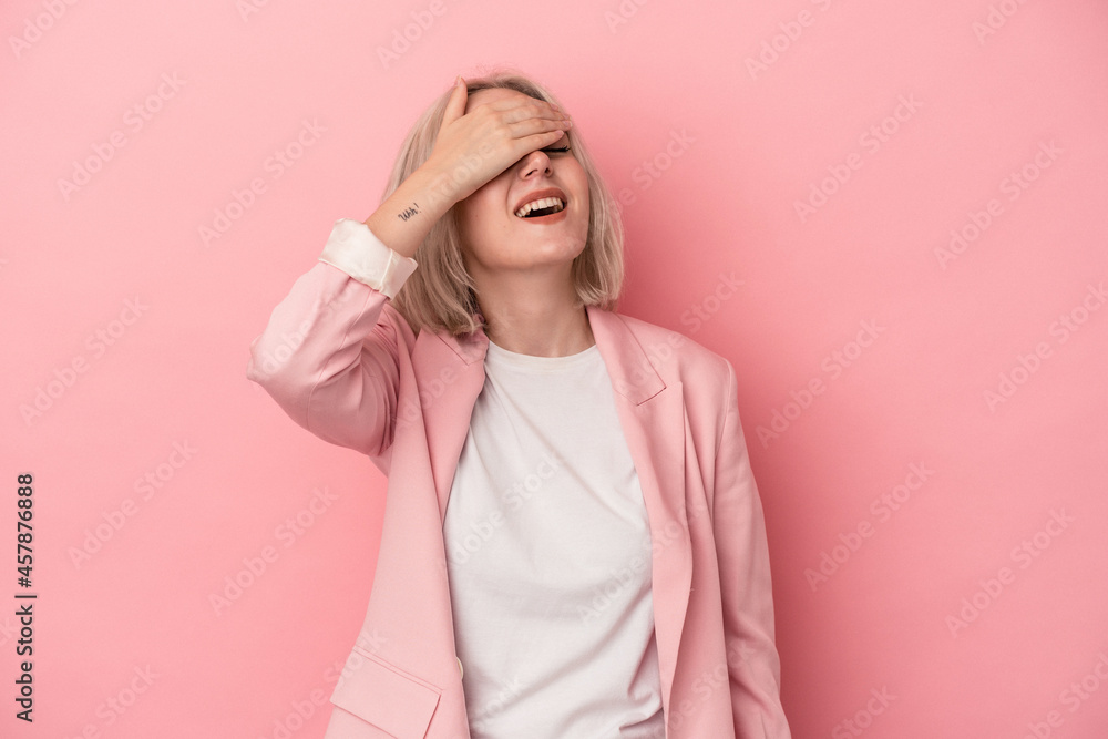 Young caucasian woman isolated on pink background laughs joyfully keeping hands on head. Happiness concept. Young caucasian woman isolated on pink background laughs joyfully keeping hands on head. Happiness concept.