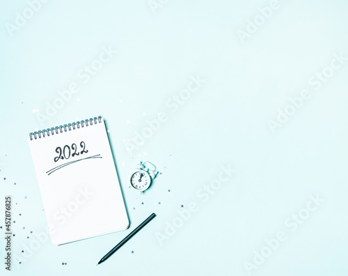 Obraz na płótnie Top view of white vintage alarm clock and empty notebook ready for New 2022 Year planing or wish list w salonie
