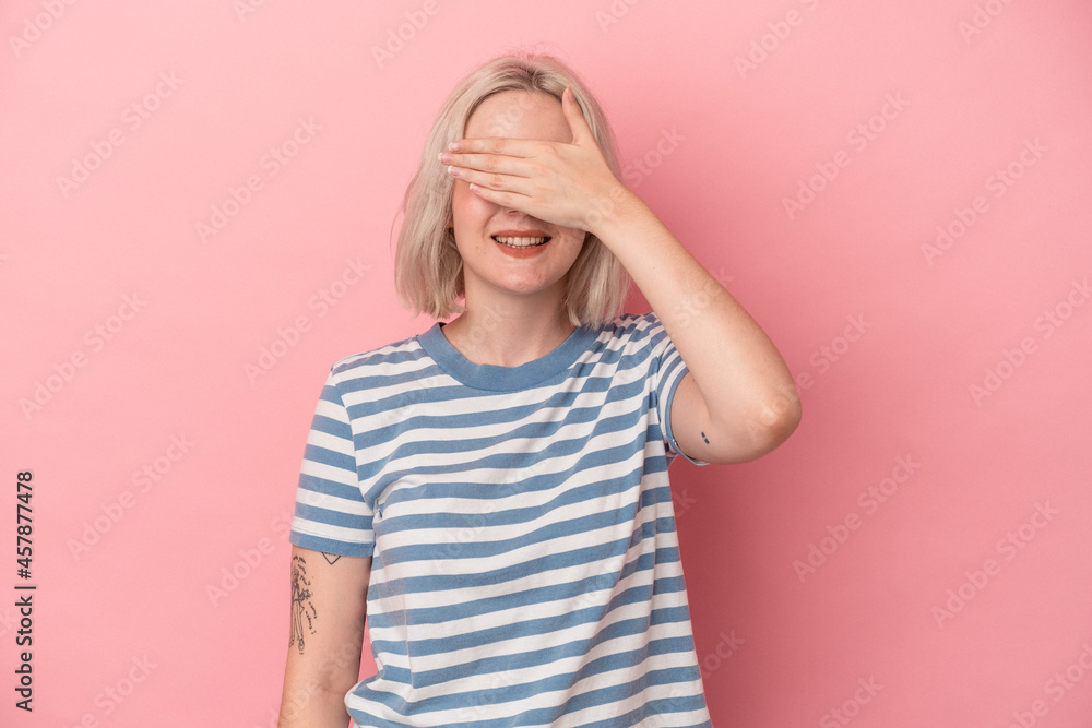 Young caucasian woman isolated on pink background covers eyes with hands, smiles broadly waiting for a surprise. Young caucasian woman isolated on pink background covers eyes with hands, smiles broadly waiting for a surprise.