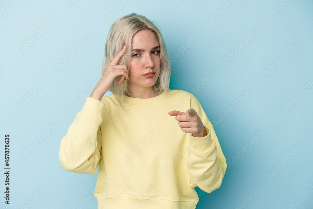Young caucasian woman isolated on blue background pointing temple with finger, thinking, focused on a task. Young caucasian woman isolated on blue background pointing temple with finger, thinking, focused on a task.