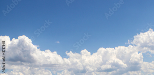 Banner or replacement sky of cloud bank with clear blue sky above - room for copy.