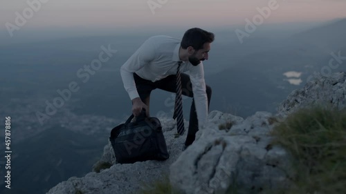 Businessman climbs over the rock. Success