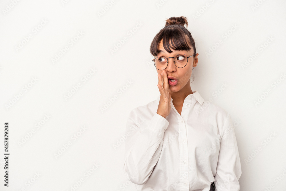 Young mixed race business woman isolated on white background  is saying a secret hot braking news and looking aside
