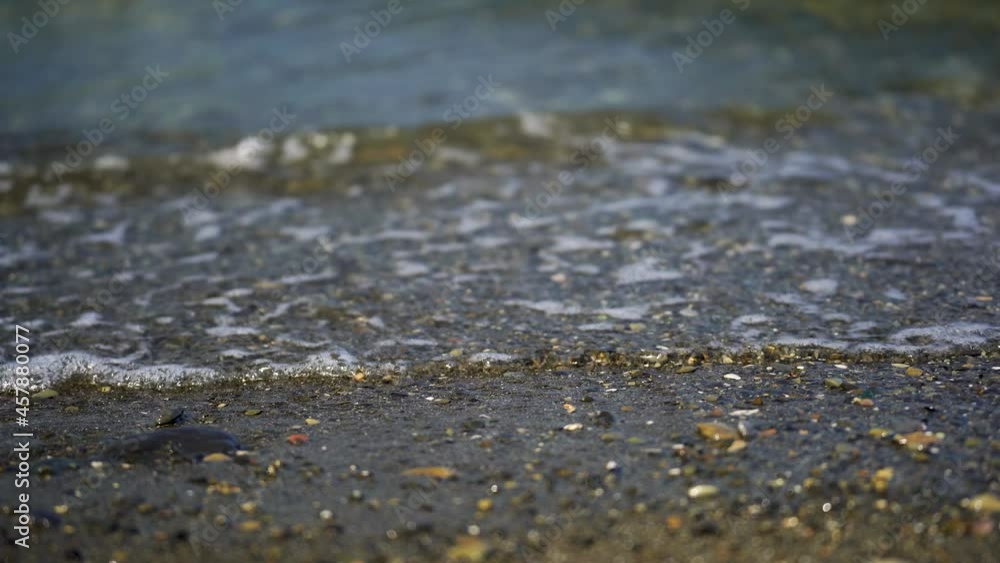 Beautiful view of the azure small waves illuminated by the sun, rolling on the beach Beautiful view of the azure small waves illuminated by the sun, rolling on the beach