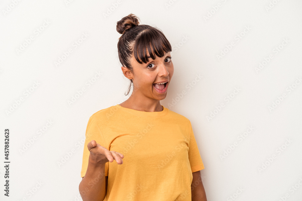 Young mixed race woman isolated on white background stretching hand at camera in greeting gesture. Young mixed race woman isolated on white background stretching hand at camera in greeting gesture.