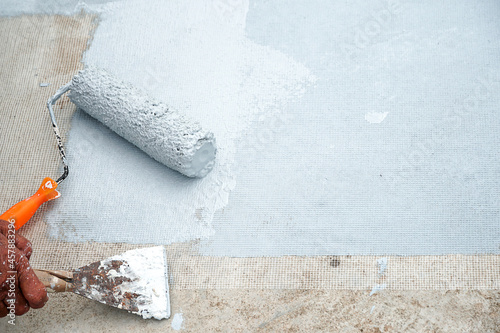 Hand painted gray flooring with paint rollers for waterproof, reinforcing net,Repairing waterproofing deck flooring.	
