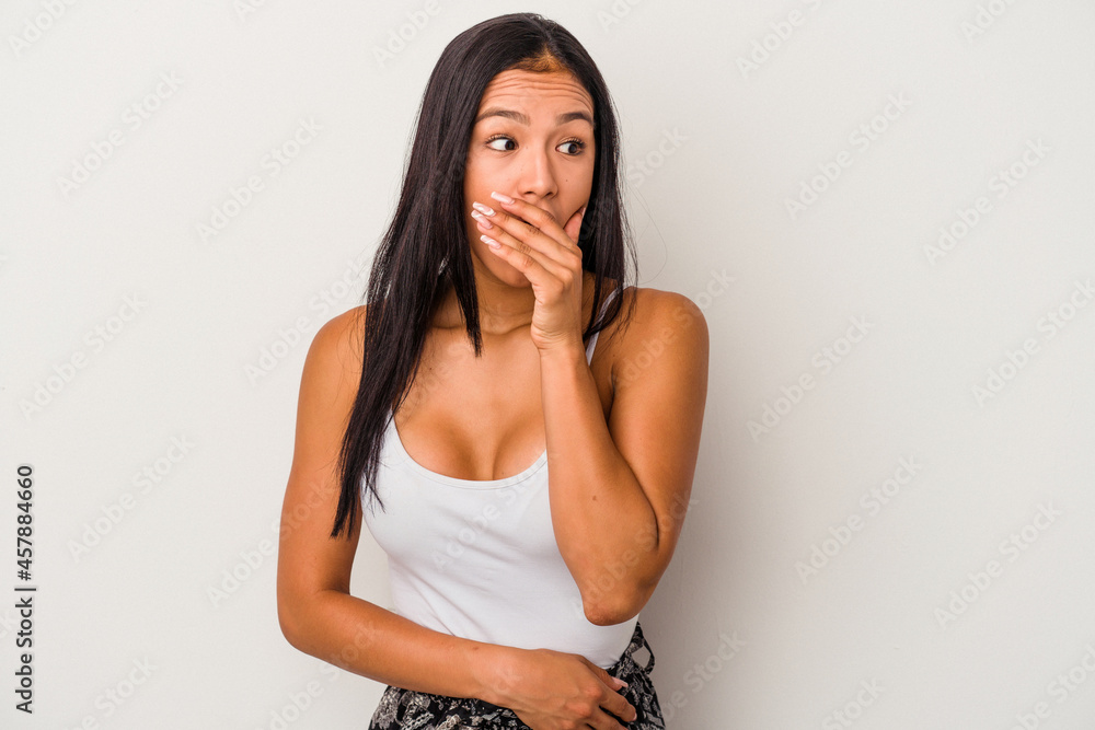 Young latin woman isolated on white background thoughtful looking to a copy space covering mouth with hand. Young latin woman isolated on white background thoughtful looking to a copy space covering mouth with hand.