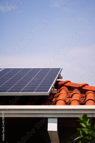 Solar panels on the red roof in a sunny and cloudy day. Photovoltaic instalation image. photo