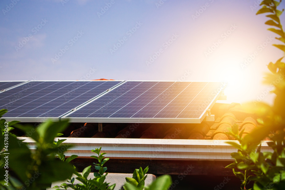 © Andre Nery - Solar panels on the red roof in a sunny and cloudy day. Photovoltaic instalation image.