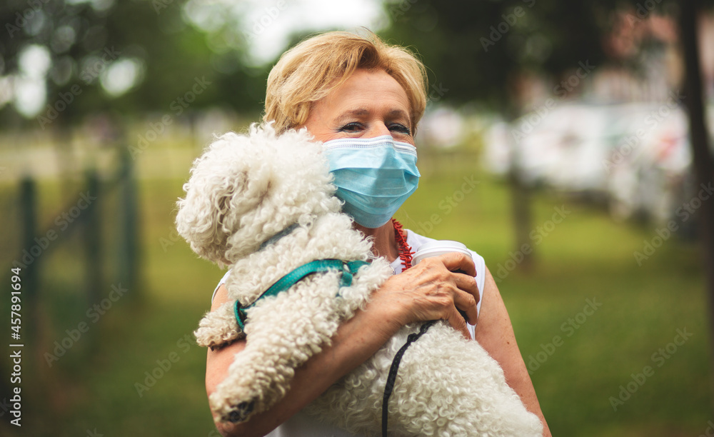 Portrait of a beautiful Blonde Woman Wearing a Mask.
Senior woman walking with dog, during Covid-19 pandemic, outdoor. Portrait of a beautiful Blonde Woman Wearing a Mask.
Senior woman walking with dog, during Covid-19 pandemic, outdoor.