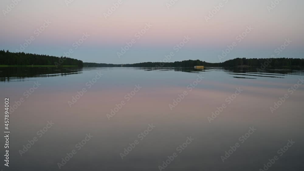 4K tranquil view of the closeup dandelion beside the lake during sunset through the horizon. Cloud reflection on the water 4K video. 4K tranquil view of the closeup dandelion beside the lake during sunset through the horizon. Cloud reflection on the water 4K video.