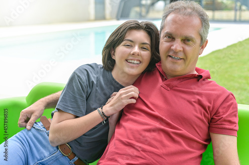 Portrait of a father and his accomplice daughter sitting in their garden