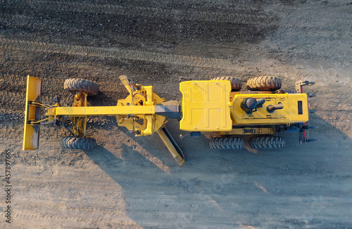 Grader Road Construction Grader industrial machine on construction of new roads. the blade of a motor grader in the process of leveling a sandy road foundation. Grader is working on road construction.