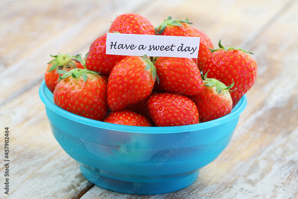Have a sweet day note with fresh, sweet strawberries in blue plastic bowl