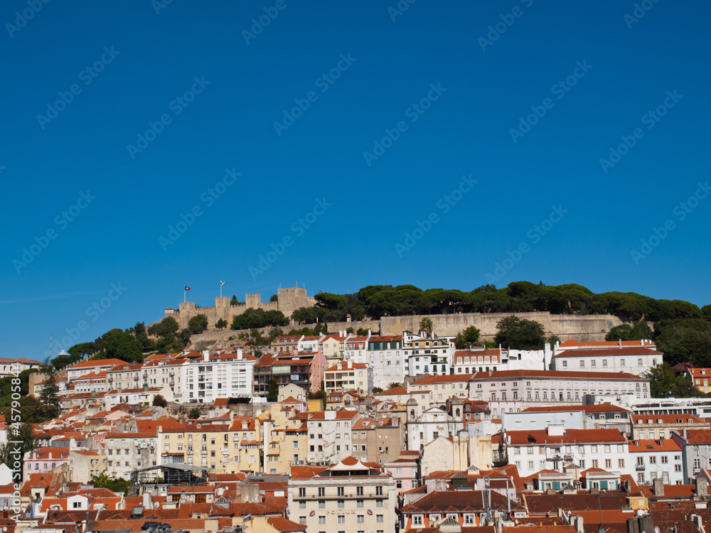 Lisbon St George Castle on top of the hill with houses below and blue sky