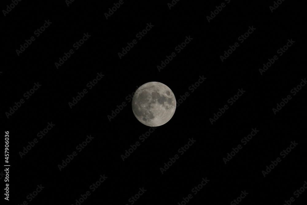 Photo of a bright moon against a dark night sky. Photo of a bright moon against a dark night sky.