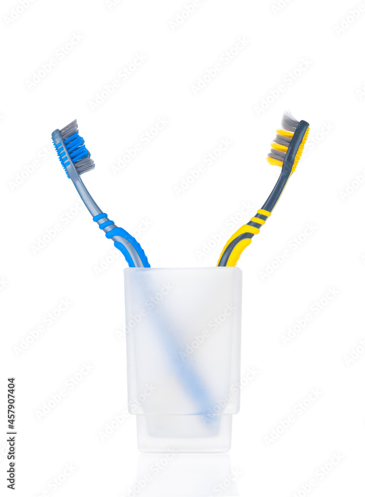 Two toothbrushes in glass isolated on white background Two toothbrushes in glass isolated on white background