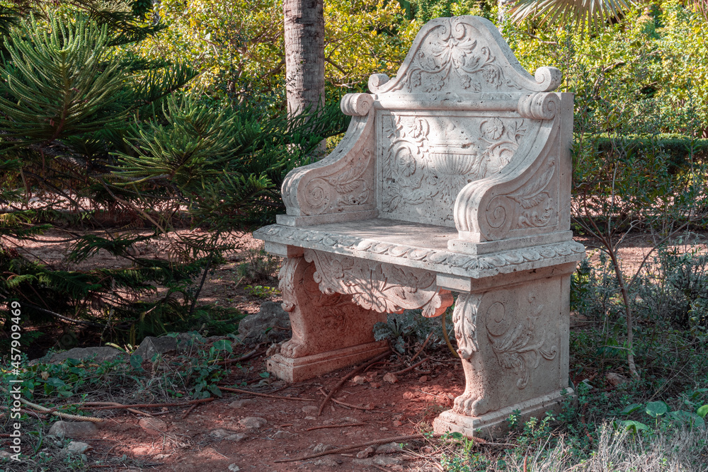 Stone bench with engraved details, outside a botanical garden. Stone bench with engraved details, outside a botanical garden.