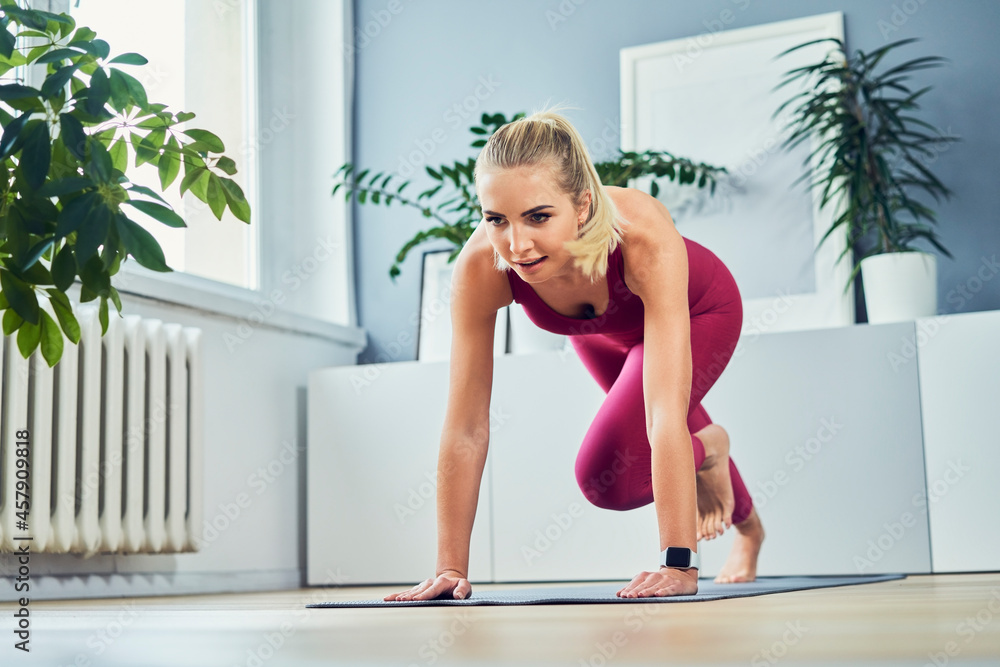 Fit woman exercise at home doing climbers exercise wearing sports clothing