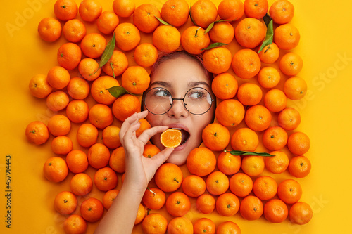 young and cheerful girl among oranges. Emotion concept.