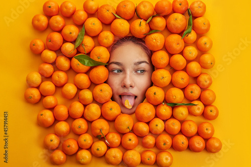 young and cheerful girl among oranges. Emotion concept.