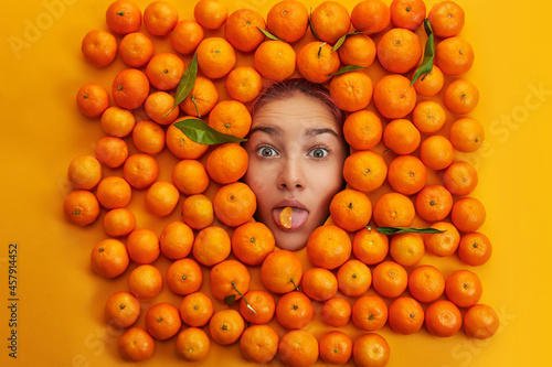 young and cheerful girl among oranges. Emotion concept.