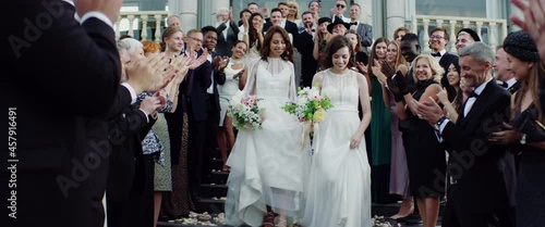 Wallpaper Mural Candid shot of two female lesbian LGBT brides toss their bouquets over their shoulders to their guests. Shot with 2x anamorphic lens Torontodigital.ca