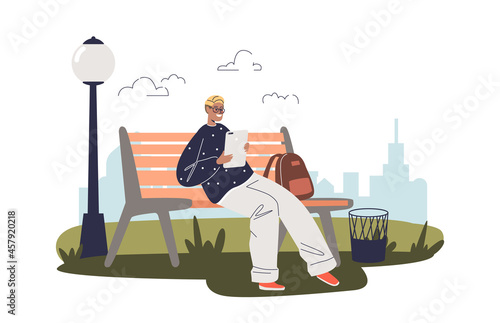 Young guy sit on bench holding digital tablet computer use gadget and wireless internet connection