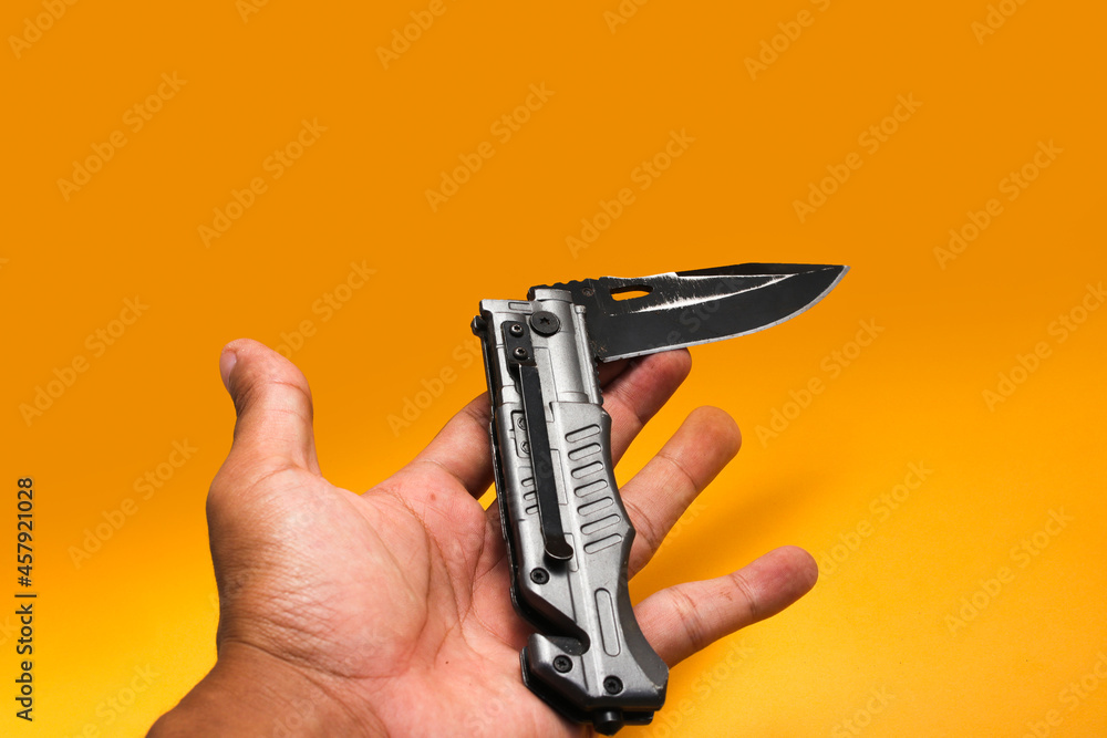 Obraz premium Stainless Folding Knife isolated on orange background
