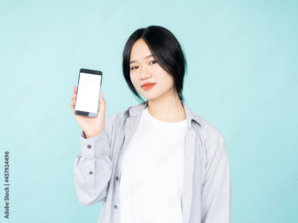 Advertising information. Asian woman. Mobile presentation. Digital technology. Happy lady showing smartphone blank screen isolated blue. Advertising information. Asian woman. Mobile presentation. Digital technology. Happy lady showing smartphone blank screen isolated blue.