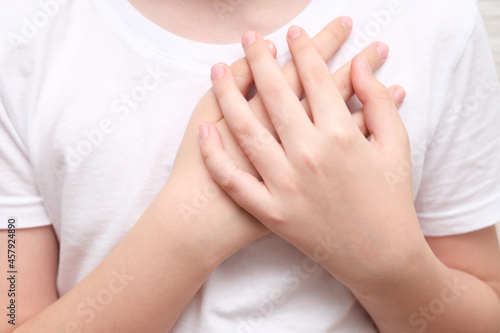 A boy showing gratitude gesture on white background  he is hopeful while praying