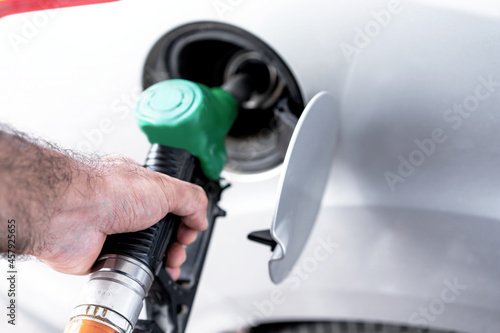 Man inserts a hose with gasoline into the car