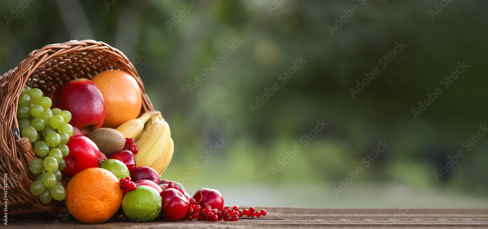 Obraz na płótnie Wicker basket with fresh fruits on table with space for text w salonie