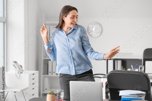 Young businesswoman dancing...