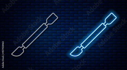 Glowing neon line Cuticle pusher icon isolated on brick wall background. Tool for manicure. Vector