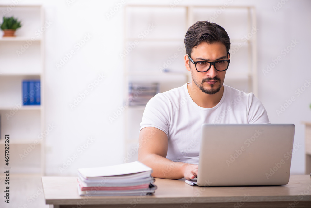 Young male student employee at workplace Young male student employee at workplace