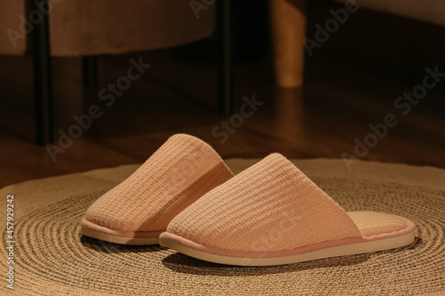 Female pink slippers on rug at home