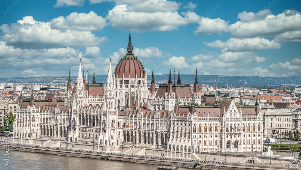 Fototapeta premium Classic view of the Parliament building in Budapest seat of the Hungarian government built in Neo Gothic style along the Danube river with cloudy blue sky
