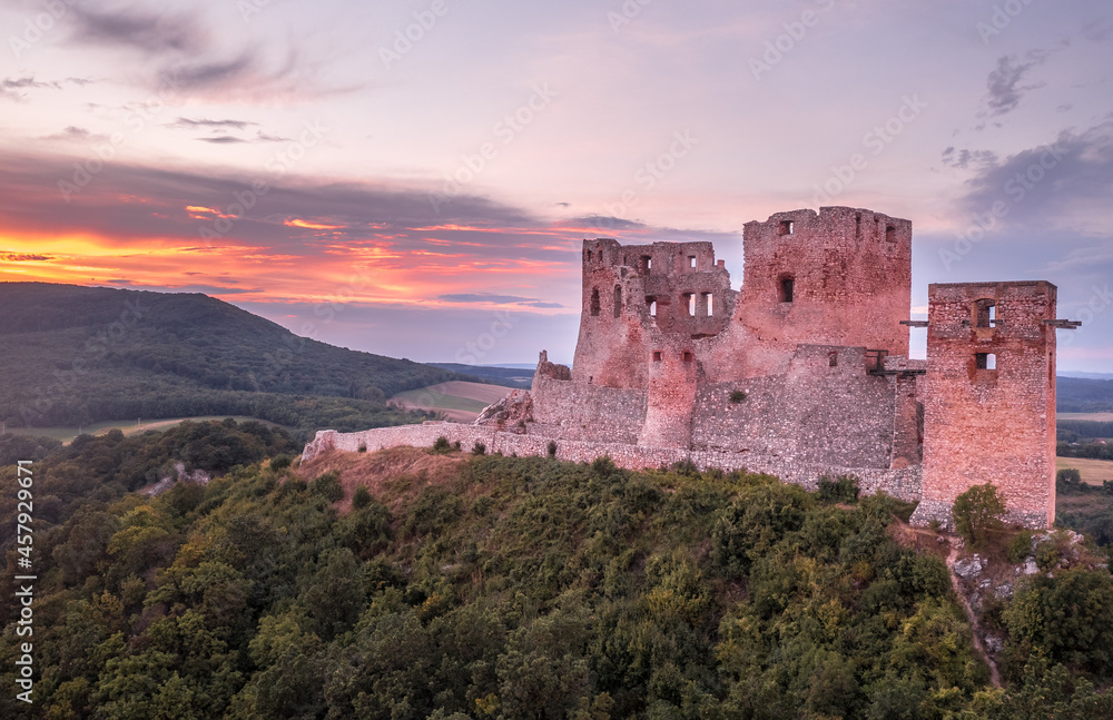 Aerial view of ruined Gothic Csesznek castle in the Bakony region of Hungary in Veszprem county with old palace building, gate tower with colorful dramatic sunset Aerial view of ruined Gothic Csesznek castle in the Bakony region of Hungary in Veszprem county with old palace building, gate tower with colorful dramatic sunset