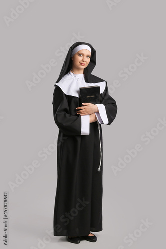 Young nun with Bible on gre...