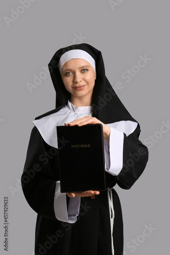 Young nun with Bible on gre...