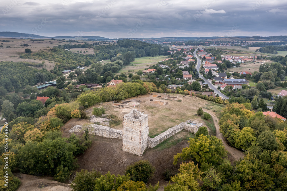 Aerial view of ruined medieval Gothic castle Essegvar on a hilltop above Band in Veszprem county, Bakony mountains Hungary with partially restored square tower and excavation digs on the courtyard Aerial view of ruined medieval Gothic castle Essegvar on a hilltop above Band in Veszprem county, Bakony mountains Hungary with partially restored square tower and excavation digs on the courtyard