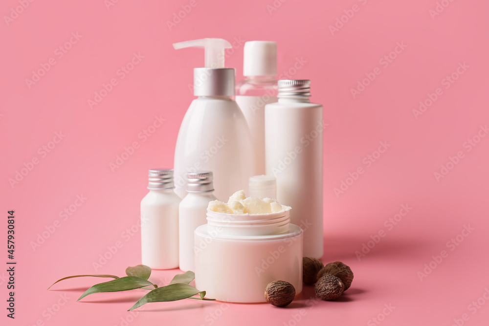 Jar of shea butter and cosmetic products on color background
