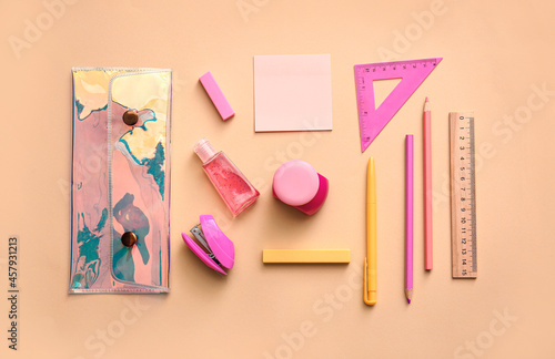 Composition with pencil case, stationery and sanitizer on color background