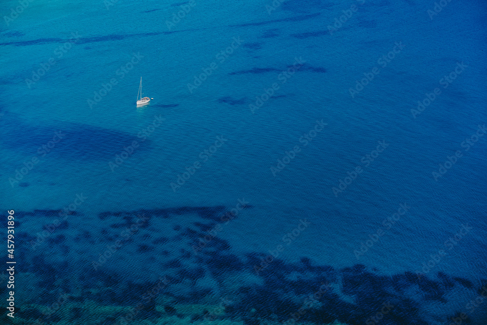 Aerial drone view to seascape with clear water. Driving motor boat sails on blue surface. Amazing azure background. Travel destination, universal nature, powerboat sports