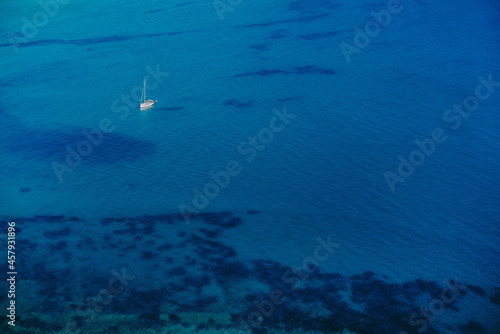 Aerial drone view to seascape with clear water. Driving motor boat sails on blue surface. Amazing azure background. Travel destination, universal nature, powerboat sports