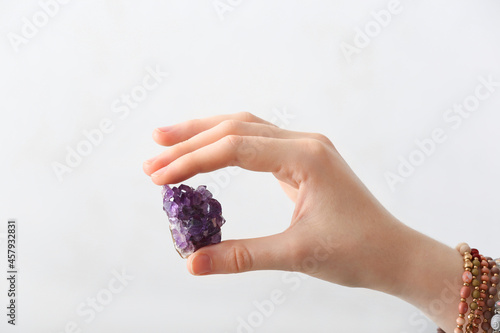 Vászonkép Female hand with beautiful amethyst on light background