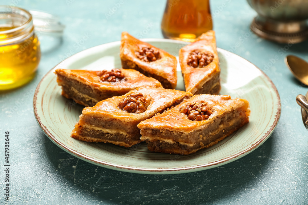 Plate with tasty baklava on blue background Plate with tasty baklava on blue background